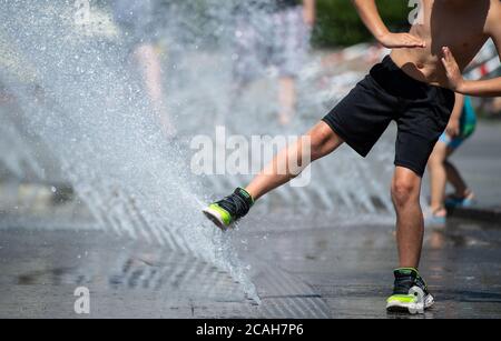 Munich, Allemagne. 07e août 2020. Un garçon joue avec l'eau d'un puits au Stachus. Credit: Sven Hoppe/dpa/Alay Live News Banque D'Images