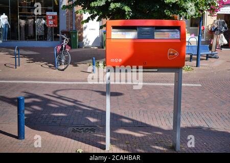 Benekom,pays-Bas-juillet,30,2020:boîte aux lettres rouge hollandaise, par la société de logistique PostNL dans un quartier de banlieue de rue commerçante. Boîte aux lettres Banque D'Images