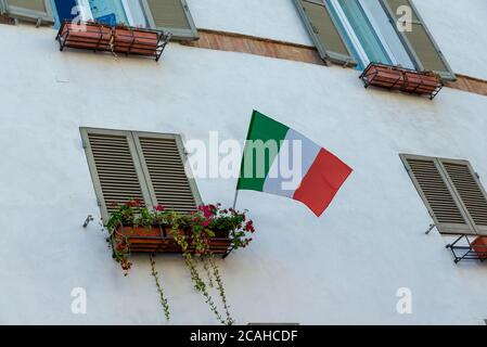 Drapeau italien placé sur un balcon dans la ville de Spoleto Banque D'Images