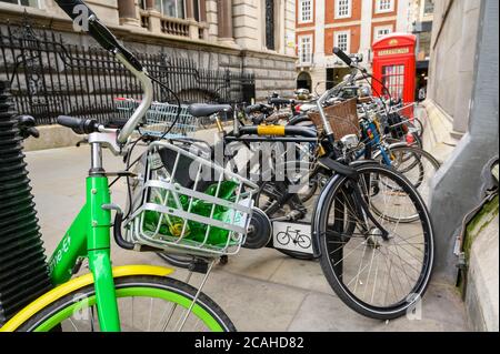 LONDRES - 04 FÉVRIER 2020: Le panier avant d'un vélo de location d'assistance électrique Lime garé avec des vélos réguliers avec un téléphone rouge traditionnel dans le TH Banque D'Images