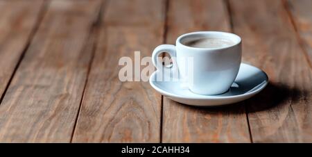 Une tasse de café sur une ancienne table en bois. Café aromatique avec mousse Banque D'Images