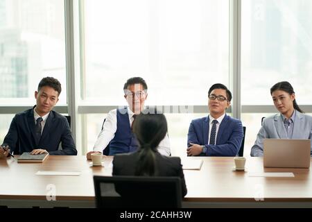 une jeune femme d'affaires asiatique interviewée par un groupe de cadres d'entreprise Banque D'Images