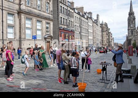 Royal Mile, Édimbourg, Écosse, Royaume-Uni. 7 août 2020. « Todd Various » Edinburgh Street Performer décide que le spectacle doit se poursuivre. Le Fringe Festival 2020 a été annulé en raison de la pandémie Covid-19, mais aujourd'hui aurait été le jour d'ouverture de cette année Fringe événement. L'annulation est la première depuis qu'elle a commencé en 1947. Todd portant une visière de protection a effectué des tours magiques pour un petit public socialement distancé comme c'est tout ce qu'il est autorisé à faire. Pendant la représentation, il a constamment dû demander aux passants de marcher mais de revenir pour son prochain spectacle toutes les demi-heures. Banque D'Images