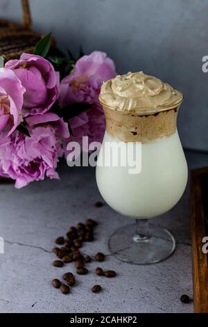 Milk shake. Dalgona Coffee - le café coréen est servi sur fond de bois. Café instantané ou espresso en poudre fouetté avec du sucre et de l'eau chaude. Glacé Banque D'Images