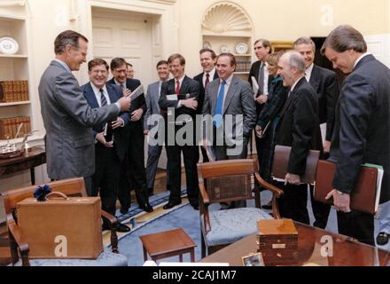 Dans ce dossier photo, le président des États-Unis George H.W. M. Bush reçoit un cadeau d'anniversaire de la part du chef de cabinet de la Maison-Blanche John Sununu et d'autres membres de son personnel supérieur, dont Richard Darman, directeur du Bureau de la gestion et du budget, du général de l'armée de l'air américaine Brent Scowcroft, conseiller à la sécurité nationale, et du chef de cabinet adjoint de la Maison-Blanche Andy Card ; C. Boyden Gray, conseiller de la Maison Blanche, et d'autres membres du personnel supérieur du Président dans le Bureau ovale de la Maison Blanche à Washington, DC, le 12 juillet 1990. Crédit obligatoire : David Valdez/Maison Blanche via CNP | utilisation dans le monde entier Banque D'Images