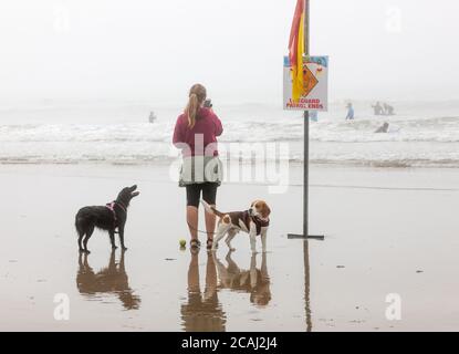 Garrettstown, Cork, Irlande. 07th August, 2020.Yvonne Kelly de passage West avec ses deux chiens Matilda et Baloo regardant les surfeurs à Garrettstown, Co. Cork, Irlande. - crédit; David Creedon / Alamy Live News Banque D'Images