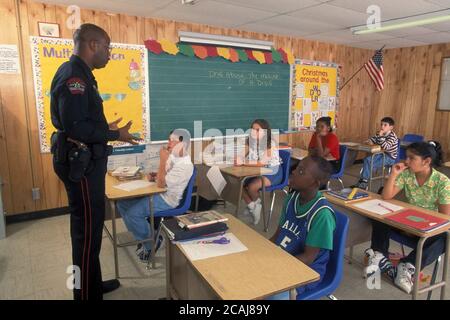 Un policier afro-américain discutant de la sensibilisation à la drogue dans une classe de 4e année. Autorisation du modèle ©Bob Daemmrich Banque D'Images