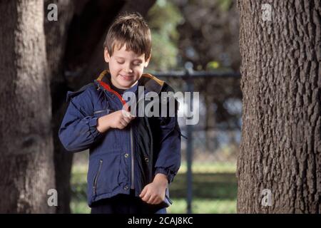 Austin Texas États-Unis : un garçon anglo de cinq ans zippe son manteau chaud le jour de l'automne dans le parc. Autorisation du modèle. ©Bob Daemmrich Banque D'Images