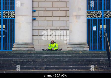 8 juillet 2020 UN homme dans une veste de haute qualité assis sur les marches de l'imposant centre de divertissement de l'hôtel de ville de Sheffield, en Angleterre. Le hall Banque D'Images