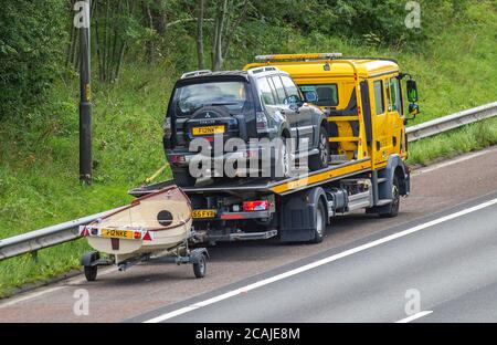 2007 Mitsubishi Shogun Elegance DI-D Lwba noir avec bateau sur une remorque d'assistance routière AA 24hr ; véhicules de dépannage de la circulation automobile, voitures décomposées sur l'épaule dure.Routes britanniques, moteurs, automobile sur le réseau autoroutier M6. Banque D'Images