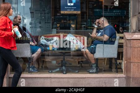 Glasgow, Écosse, Royaume-Uni. 7 août 2020. Météo Royaume-Uni. Clients dans la fenêtre de Caffe Nero sur Trongate ayant un café. Credit: SKULLY/Alay Live News Banque D'Images