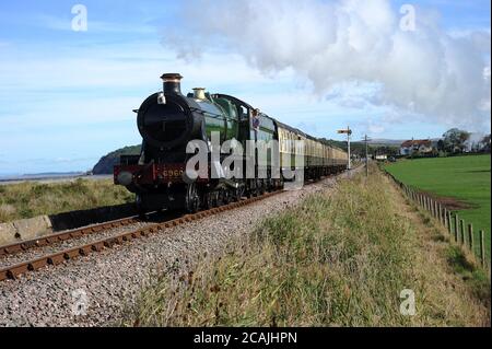 'Raveningham Hall' quitte l'ancre bleue avec un Bisops Lydeard - train Minehead. Banque D'Images