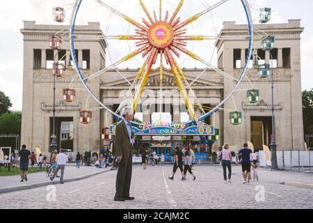 MUNICH, ALLEMAGNE - 25 juillet 2020 : un aîné se tient dans la rue et regarde ses petits-enfants. Festival public d'été dans la ville de Munich despi Banque D'Images