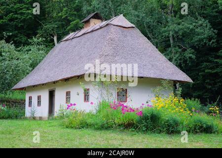 Ancienne maison rurale avec toit de chaume et murs blanchis à la chaux. Village historique en Ukraine, préserver les traditions et la culture. Banque D'Images