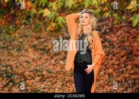 Tenues décontractées confortable pour la fin de l'automne. Adorable petite fille blonde posing in outfit chaleureux et cosy de l'automne nature fond flou. Création pour agréable fin de semaine. Femme à pied. La lumière au coucher du soleil Tenue confortable. Banque D'Images