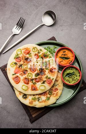 Uthappam ou uttapam est un type de dosa du sud de l'Inde qui est plus épais, avec des garnitures de tomate, d'oignon et de piment Banque D'Images
