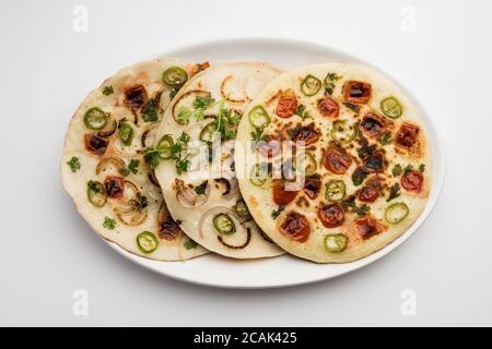 Uthappam ou uttapam est un type de dosa du sud de l'Inde qui est plus épais, avec des garnitures de tomate, d'oignon et de piment Banque D'Images