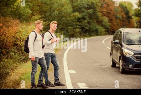 Geste de randonnée. Commencez une grande aventure dans votre vie avec la randonnée pédestre. Compagnie amis voyageurs qui déchire à la route nature fond. Voyageurs en route. Des amis qui voyagent avec des hitchhikers. Banque D'Images