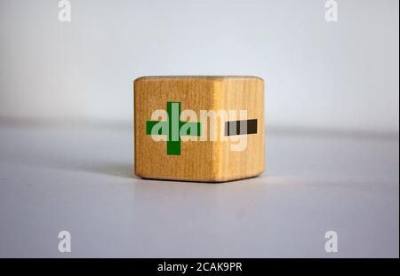 Le concept des opposés, blog de bois avec plus et moins sur fond bleu, plat, espace de copie. Banque D'Images