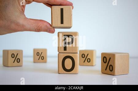 Main masculine plaçant un cube avec la lettre I au-dessus d'un autre cube. Mot IPO. Magnifique fond blanc. Concept de processus d'entreprise réussis. Banque D'Images