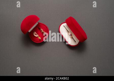 Deux boîtes à bijoux rouges avec bijoux sur fond noir. Vue de dessus Banque D'Images