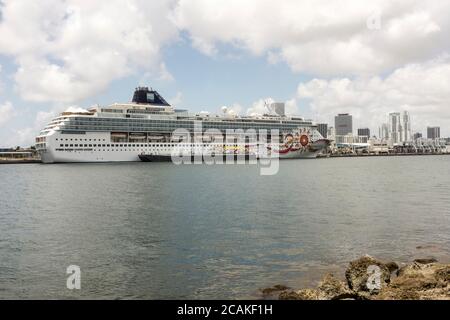 Un navire Norwegian Cruise Lines avec une barge alonside, amarré à PortMiami, capitale mondiale des croisières, à Miami, Floride, États-Unis Banque D'Images