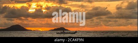 Coucher de soleil sur les îles de Flores, près de Labuan Bajo, Indonésie, avec des bateaux en premier plan Banque D'Images