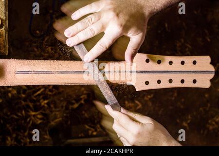 Luthier qui travaille, façonnant un cou de guitare brésilienne Banque D'Images