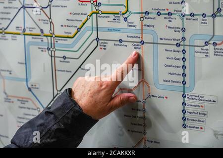 London, Royaume-Uni - le 02 février 2019 : une femme âgée pointe de la main vers la station d'eau du Canada sur la carte du métro de Londres, alors qu'elle planifie son voyage. Sous-groupe Banque D'Images