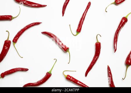 Piments rouges chauds sur fond blanc. plat, vue du dessus Banque D'Images
