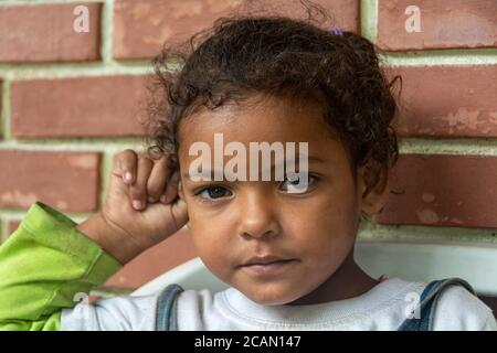 Un enfant pose pour la photo, avant d'être appelé pour le déjeuner. Les enfants, les mères et les personnes âgées ont la priorité de manger en premier. Dans la paroisse Maria Banque D'Images