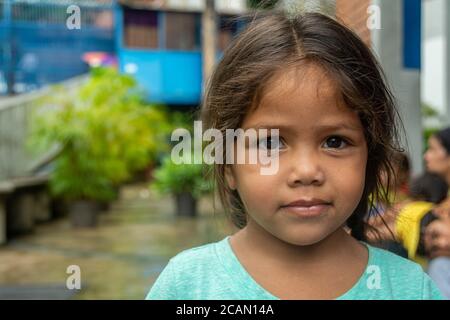 Un enfant pose pour la photo, avant d'être appelé pour le déjeuner. Les enfants, les mères et les personnes âgées ont la priorité de manger en premier. Dans la paroisse Maria Banque D'Images