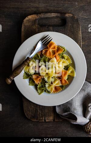 Faire bouillir des pâtes saines d'épinards et de farfalle de carotte dans un bol Banque D'Images