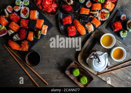 Sushi avec divers sashimis, petits pains à sushis et thé servis sur ardoise de pierre Banque D'Images