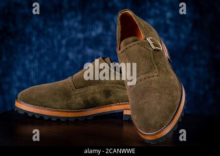 Chaussures classiques en daim vert pour hommes sur fond bleu Banque D'Images