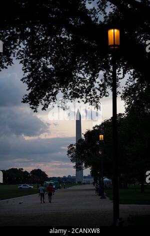 Washington, États-Unis. 7 août 2020. Les gens marchent sur le National Mall pendant le coucher du soleil près du Washington Monument à Washington, DC, les États-Unis, le 7 août 2020. Le taux de chômage aux États-Unis a chuté en juillet pour le troisième mois, ce qui indique une amélioration du marché du travail ravagé par la pandémie COVID-19. Mais les analystes mettent en garde contre le fait que les incertitudes persistent et que la reprise a beaucoup à faire. Les employeurs américains ont ajouté 1.7 millions d'emplois en juillet, et le taux de chômage a chuté à 10.2 pour cent en raison des efforts de réouverture, a rapporté vendredi le Bureau américain des statistiques du travail. Credit: Liu Jie/Xinhua/Alay Live News Banque D'Images