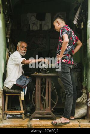 rajasthan / inde - juillet 25 2020 : jeune homme adulte regardant et apprenant la couture de son maître, vieil homme enseignant son jeune étudiant la couture Banque D'Images
