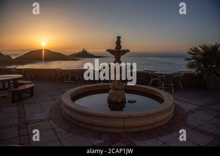 Mumbles, Swansea, Royaume-Uni. 8 août 2020. Le soleil se lève sur le phare de Mumbles près de Swansea ce matin, vu de l'extérieur du restaurant Castellamare au début d'une journée d'été du Royaume-Uni. Credit: Phil Rees/Alamy Live News Banque D'Images