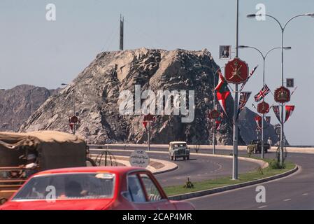 Archive image: Le Sultanat d'Oman en 1979, sept ans après le Sultan Qaboos a pris le pouvoir et a commencé à moderniser le pays. C'était encore une époque où le tourisme vers le pays en était à ses débuts. Image: Route côtière à double chaussée reliant Muscat à Muttrah. Les décorations de la route célèbrent la récente visite d'État (en 1979) de la reine Elizabeth II à Oman. Crédit: Malcolm Park Banque D'Images