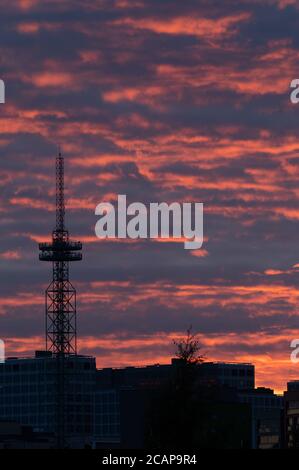 Helsinki / Finlande - 6 août 2020 : silhouette d'une grande tour de télécommunication / radiodiffusion contre un ciel rouge vif lors d'une soirée d'été trouble. Banque D'Images