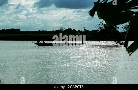 Les agriculteurs bangladais sont à bord d'un bateau en bois près du bord de la rivière Banque D'Images