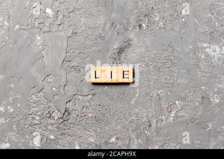 MENTIR mot écrit sur le bloc de bois. MENTEZ le texte sur la table de ciment pour votre conception, concept. Banque D'Images