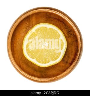 Moitié citron dans un bol en bois. Agrumes comestibles jaunes mûrs fraîchement coupés. Citron limon. Le jus de citron est utilisé à des fins culinaires et pour le nettoyage. Banque D'Images