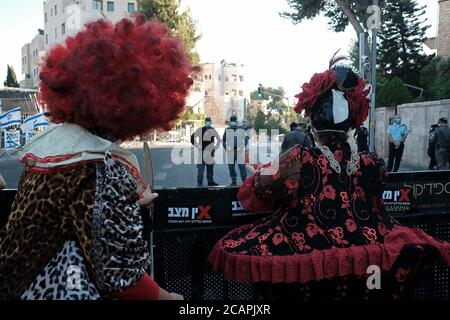 Des manifestants vêtus de clowns participent vendredi soir à une manifestation contre le Premier ministre Benjamin Netanyahu devant sa résidence officielle à Jérusalem, la dernière d'une série de manifestations l'appelant à quitter le 07 août 2020 à Jérusalem, en Israël. Les Israéliens sont descendus dans la rue dans des manifestations presque quotidiennes pour appeler à la démission de Netanyahou suite à ses accusations de corruption et à ce qu'ils appellent une mauvaise gestion de la crise du coronavirus et une agression contre la démocratie. Banque D'Images