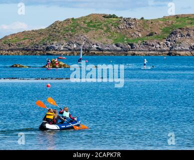 North Berwick, East Lothian, Écosse, 8 août 2020. Météo au Royaume-Uni : journée idéale pour les sports nautiques. Une chaude journée ensoleillée dans le Firth of Forth attire les gens à prendre à l'eau. Un groupe d'enfants s'amusent à pagayer dans un canot gonflable à West Bay Banque D'Images