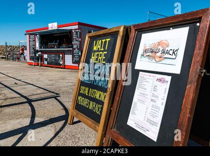 North Berwick, East Lothian, Écosse, 8 août 2020. Météo Royaume-Uni: . Une journée chaude et ensoleillée, alors que la célèbre cabane à homard dans le port se prépare pour les clients et met en place des mesures sociales de distanciation Banque D'Images