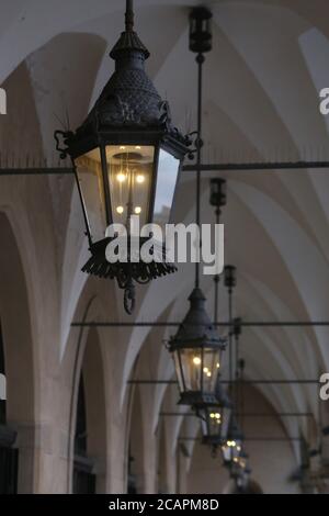 Cracovie. Cracovie. Pologne. La dernière gauche dans les lanternes de gaz de ville sous les arcades de la salle de tissu (Sukiennice) idans le marché principal place encore de travail. Banque D'Images