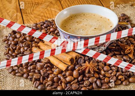 Ruban de protection sur une tasse de café et de grains de café en arrière-plan Banque D'Images