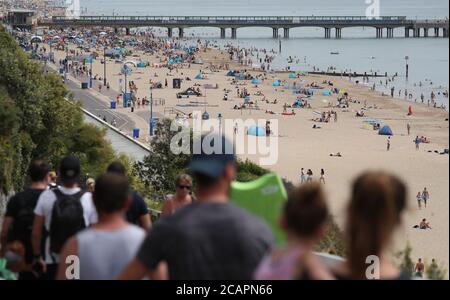 Les gens apprécient le temps chaud à la plage de Boscombe à Dorset. Banque D'Images