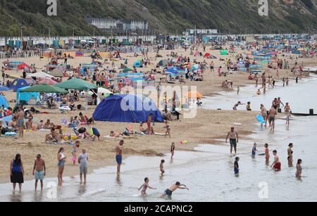 Les gens apprécient le temps chaud à la plage de Boscombe à Dorset. Banque D'Images